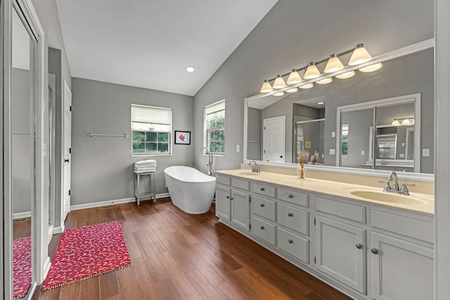 205 Seneca Ct, Franklin, TN 37067 - full bath featuring lofted ceiling, double vanity, a stall shower, a freestanding tub, and wood finished floors