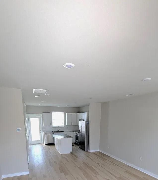 4234 Gandalf Ln, Murfreesboro, TN 37128 - kitchen with appliances with stainless steel finishes, a center island, white cabinets, light wood-type flooring, and open floor plan