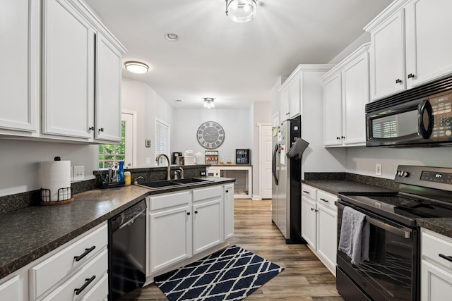 163 Bland Dr, Mount Juliet, TN 37122 - kitchen with black appliances, white cabinets, a peninsula, dark countertops, and light wood-type flooring