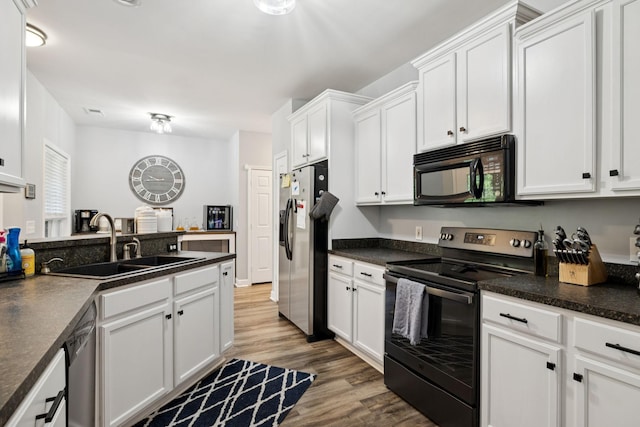 163 Bland Dr, Mount Juliet, TN 37122 - kitchen featuring black appliances, white cabinetry, wood finished floors, and dark countertops