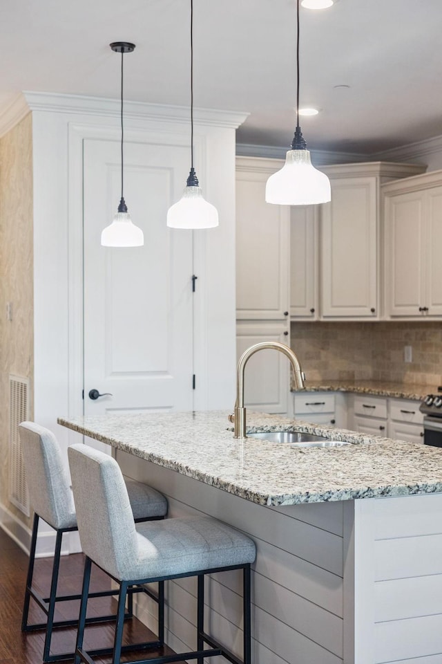 6000 Keats St Unit 202, Franklin, TN 37064 - kitchen featuring white cabinetry, a kitchen bar, dark wood-type flooring, a center island with sink, and light stone counters