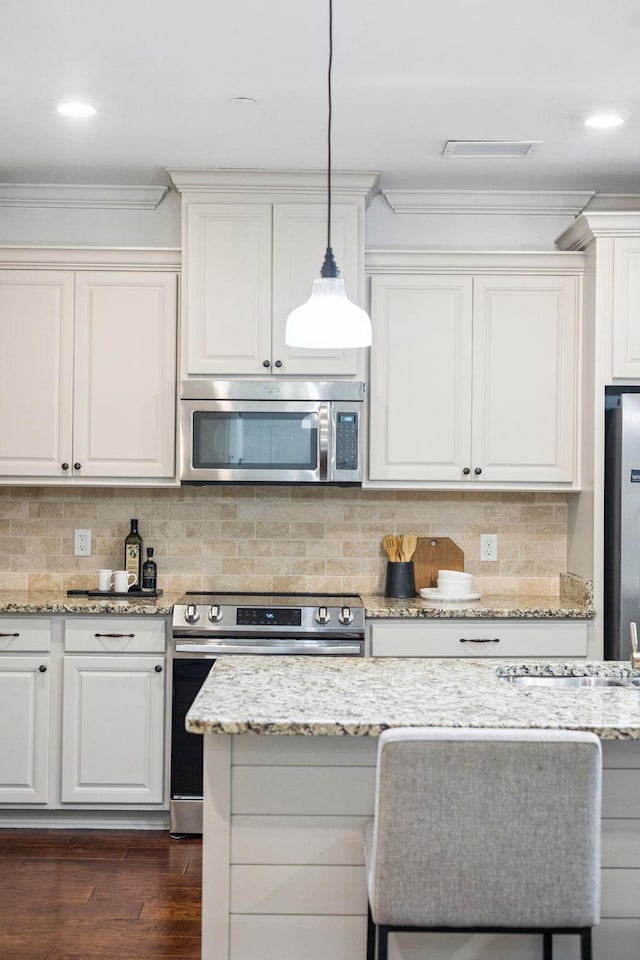 6000 Keats St Unit 202, Franklin, TN 37064 - kitchen with appliances with stainless steel finishes, crown molding, dark wood finished floors, decorative backsplash, and pendant lighting