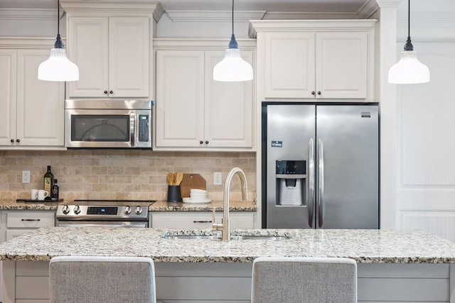 6000 Keats St Unit 202, Franklin, TN 37064 - kitchen with stainless steel appliances, light stone counters, backsplash, white cabinets, and decorative light fixtures