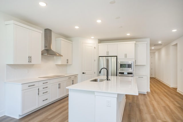 137 W Cassa Way, Mount Juliet, TN 37122 - kitchen with wall chimney range hood, stainless steel appliances, light wood-style flooring, tasteful backsplash, and recessed lighting