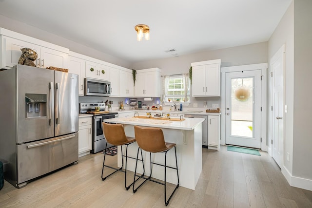 252 Caroline Dr Unit A, Murfreesboro, TN 37128 - kitchen featuring appliances with stainless steel finishes, a kitchen bar, light wood finished floors, and light countertops