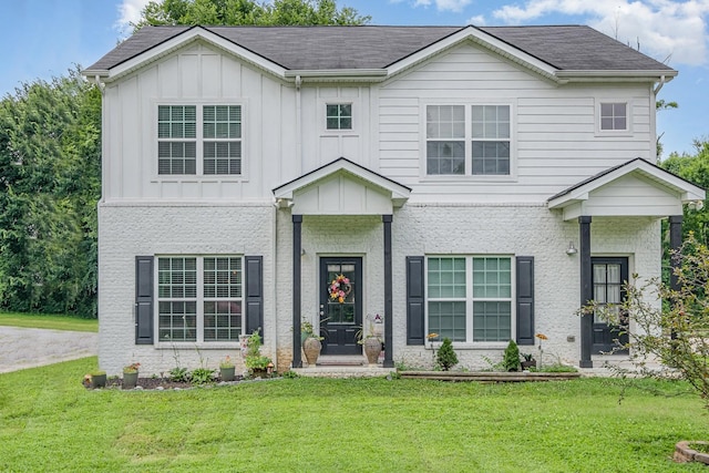 252 Caroline Dr Unit A, Murfreesboro, TN 37128 - view of front facade with board and batten siding, a front yard, brick siding, and a shingled roof