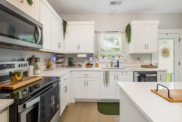 252 Caroline Dr Unit A, Murfreesboro, TN 37128 - kitchen featuring appliances with stainless steel finishes, light wood finished floors, light countertops, and white cabinets