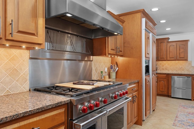 3351 Oak Burr Dr, Chattanooga, TN 37419 - kitchen with wall chimney exhaust hood, appliances with stainless steel finishes, tasteful backsplash, brown cabinetry, and recessed lighting