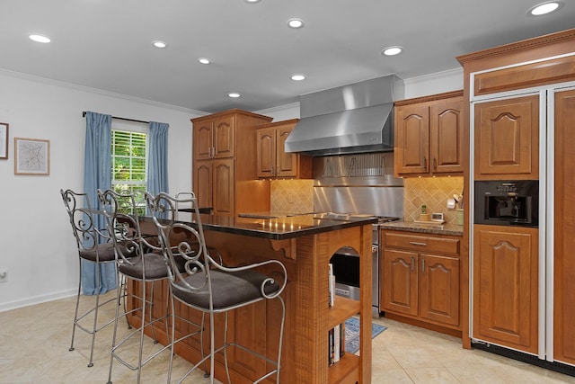 3351 Oak Burr Dr, Chattanooga, TN 37419 - kitchen with wall chimney range hood, crown molding, paneled built in refrigerator, brown cabinets, and a kitchen breakfast bar
