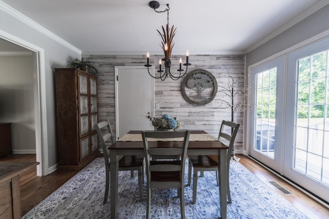 818 W Clark Blvd, Murfreesboro, TN 37129 - dining area with an accent wall, wood walls, a chandelier, ornamental molding, and wood finished floors