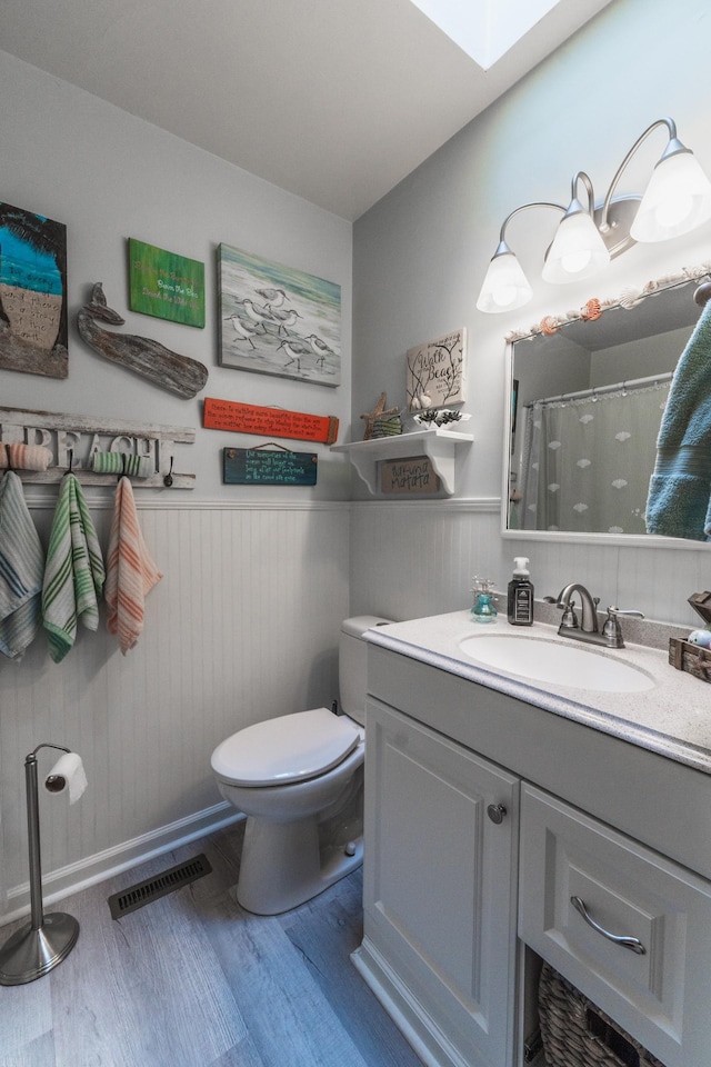 818 W Clark Blvd, Murfreesboro, TN 37129 - full bath featuring wood finished floors, vanity, a wainscoted wall, a skylight, and a shower with shower curtain