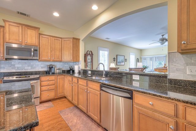 154 Salient Ln, Mount Juliet, TN 37122 - kitchen with stainless steel appliances, arched walkways, ceiling fan, light wood-type flooring, and decorative backsplash
