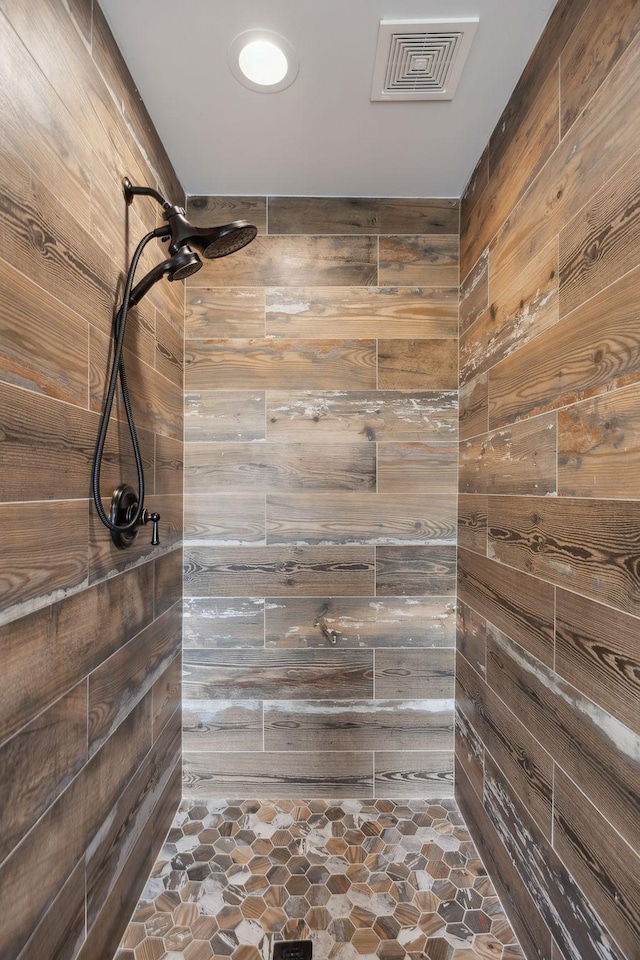1300 Stovall Ln, Mount Juliet, TN 37122 - full bathroom featuring wood walls, a tile shower, and stone finish flooring