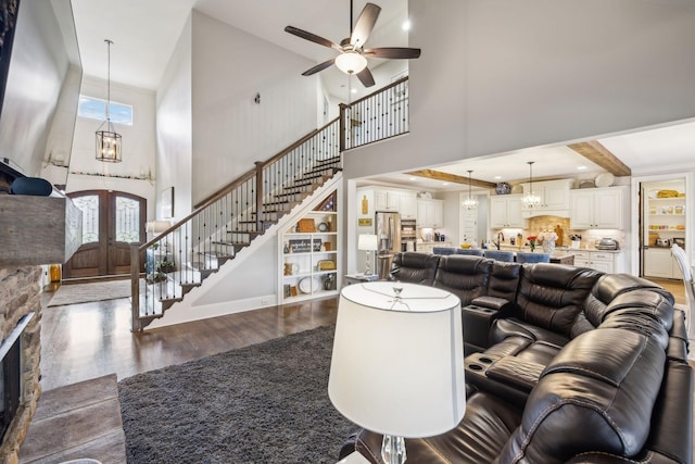 1300 Stovall Ln, Mount Juliet, TN 37122 - living room with a towering ceiling, dark wood-style flooring, stairs, ceiling fan, and a chandelier