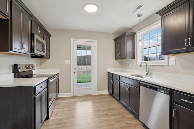 146 Irish Hls, Clarksville, TN 37042 - kitchen with appliances with stainless steel finishes, dark brown cabinetry, and light wood-style floors
