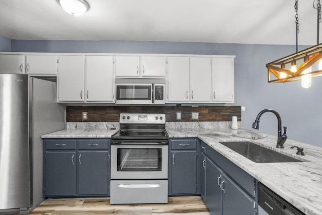 732 Charlie Gann Rd, Old Hickory, TN 37138 - kitchen featuring stainless steel appliances, white cabinetry, light wood finished floors, decorative light fixtures, and light stone countertops