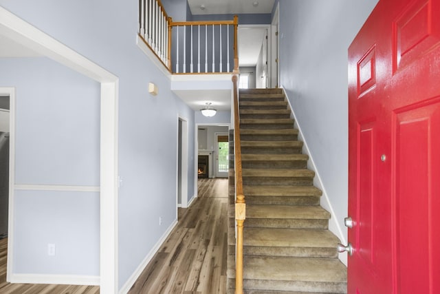 732 Charlie Gann Rd, Old Hickory, TN 37138 - stairs with wood finished floors, a warm lit fireplace, and a towering ceiling