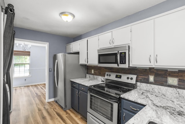 732 Charlie Gann Rd, Old Hickory, TN 37138 - kitchen with appliances with stainless steel finishes, a chandelier, white cabinets, decorative backsplash, and light wood-type flooring