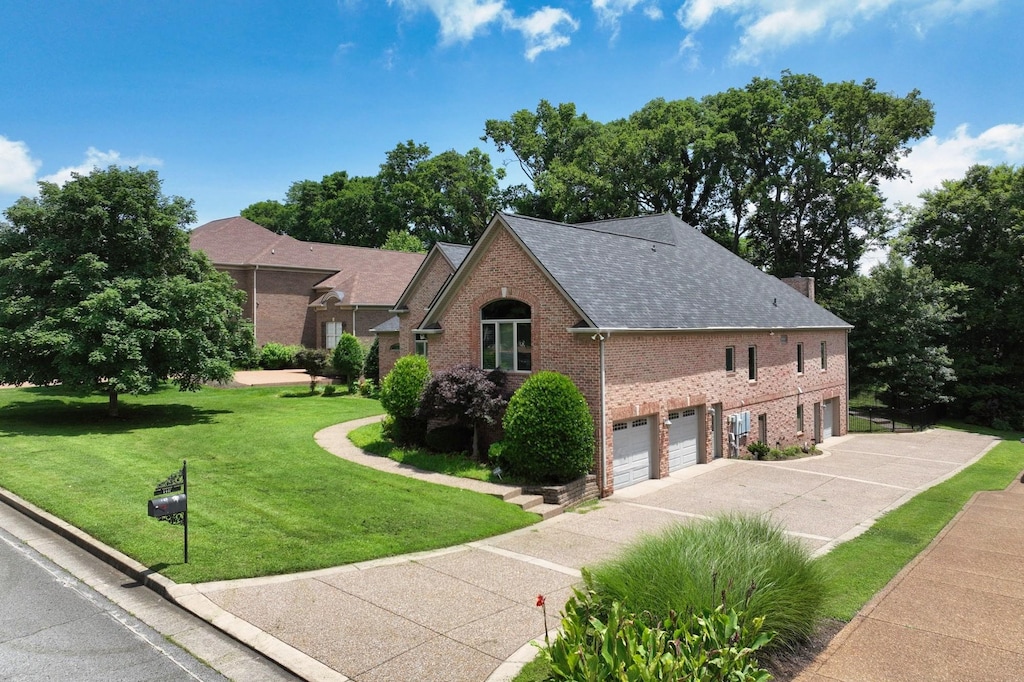 1440 Station Four Ln, Old Hickory, TN 37138 - view of front of house featuring brick siding, driveway, an attached garage, a front yard, and roof with shingles