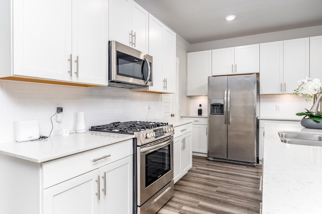 1013 Violet St, Spring Hill, TN 37174 - kitchen with appliances with stainless steel finishes, white cabinets, decorative backsplash, light stone counters, and recessed lighting