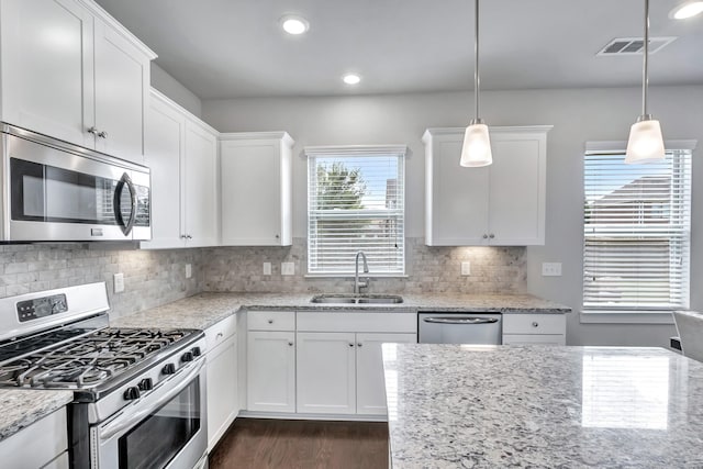 4905 Kingdom Dr, Murfreesboro, TN 37128 - kitchen featuring appliances with stainless steel finishes, dark wood-style flooring, white cabinets, hanging light fixtures, and light stone counters