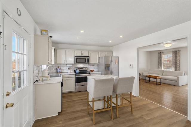 2720 Buckner Rd, Thompsons Station, TN 37179 - kitchen with stainless steel appliances, tasteful backsplash, light wood-style floors, a kitchen island, and recessed lighting