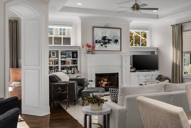 1450 Championship Blvd, Franklin, TN 37064 - living room featuring a raised ceiling, a ceiling fan, dark wood-type flooring, crown molding, and a brick fireplace