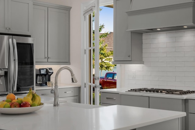 1450 Championship Blvd, Franklin, TN 37064 - kitchen featuring gray cabinets, stainless steel appliances, backsplash, custom range hood, and light countertops