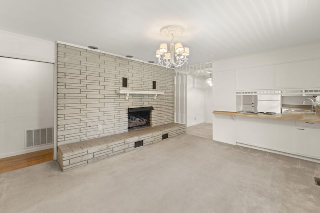 307 Mary Sharp Dr, Decherd, TN 37324 - unfurnished living room featuring a chandelier, a fireplace, and carpet flooring