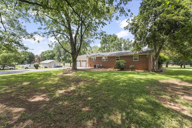 307 Mary Sharp Dr, Decherd, TN 37324 - view of side of home with a yard, an attached garage, driveway, and brick siding