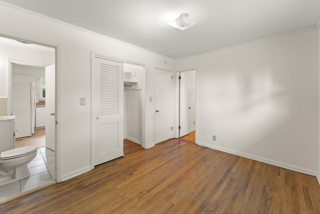 307 Mary Sharp Dr, Decherd, TN 37324 - unfurnished bedroom featuring wood finished floors, crown molding, freestanding refrigerator, and a closet