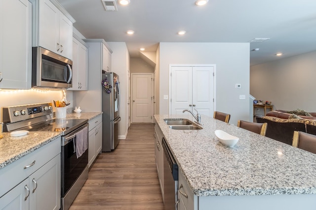 135 Millers Ln, Calhoun, GA 30701 - kitchen featuring stainless steel appliances, a center island with sink, dark wood-type flooring, light stone countertops, and recessed lighting