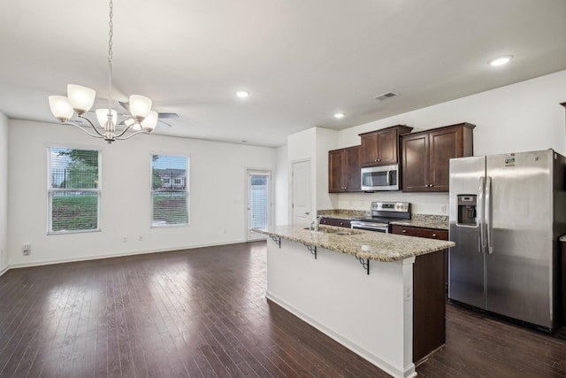 3927 Cannonsgate Ln, Murfreesboro, TN 37128 - kitchen with stainless steel appliances, dark brown cabinets, light stone countertops, a kitchen breakfast bar, and a chandelier
