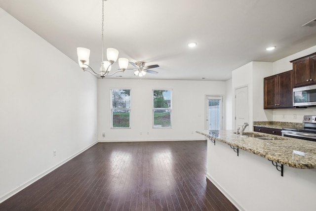 3927 Cannonsgate Ln, Murfreesboro, TN 37128 - kitchen with appliances with stainless steel finishes, a kitchen bar, dark brown cabinetry, a chandelier, and light stone counters