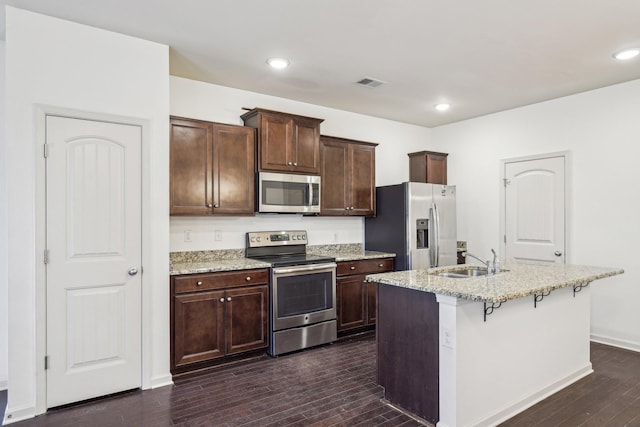 3927 Cannonsgate Ln, Murfreesboro, TN 37128 - kitchen with appliances with stainless steel finishes, dark wood-style flooring, light stone counters, a center island with sink, and recessed lighting