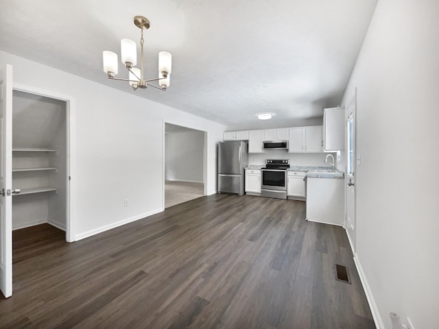 2919 Sams Ct, Spring Hill, TN 37174 - kitchen featuring appliances with stainless steel finishes, dark wood-type flooring, white cabinetry, a chandelier, and decorative light fixtures