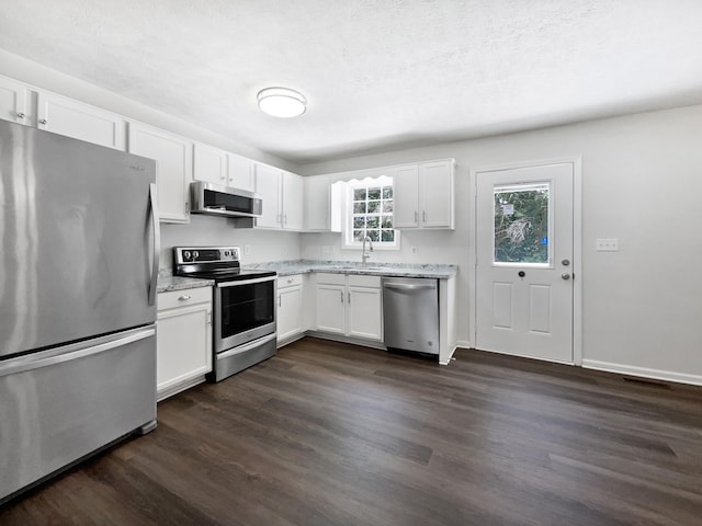 2919 Sams Ct, Spring Hill, TN 37174 - kitchen featuring stainless steel appliances, white cabinetry, dark wood-style floors, and light stone countertops