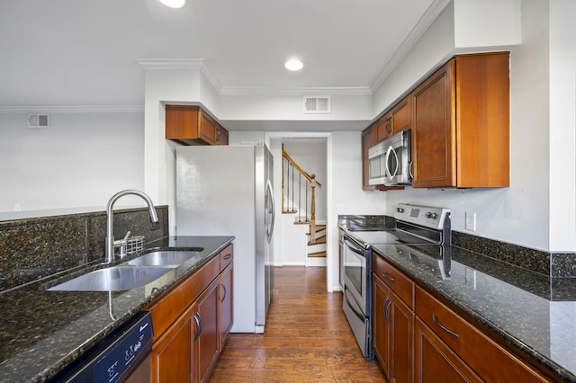 1900 Richard Jones Rd Unit X2, Nashville, TN 37215 - kitchen featuring stainless steel appliances, dark wood finished floors, ornamental molding, dark stone countertops, and brown cabinetry