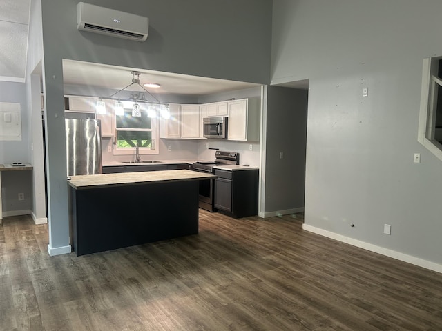 370 Alpine Rd, Camden, TN 38320 - kitchen with stainless steel appliances, dark wood-style flooring, a wall unit AC, pendant lighting, and white cabinetry