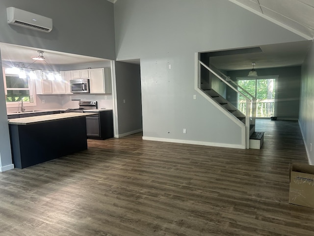 370 Alpine Rd, Camden, TN 38320 - kitchen with light countertops, a wall unit AC, appliances with stainless steel finishes, dark wood-style flooring, and a high ceiling