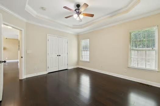 1604 Yarmouth Ct, Old Hickory, TN 37138 - unfurnished bedroom with ornamental molding, a raised ceiling, multiple windows, dark wood finished floors, and a closet