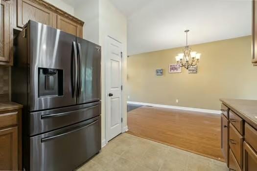 1604 Yarmouth Ct, Old Hickory, TN 37138 - kitchen featuring stainless steel fridge, a chandelier, brown cabinetry, and hanging light fixtures