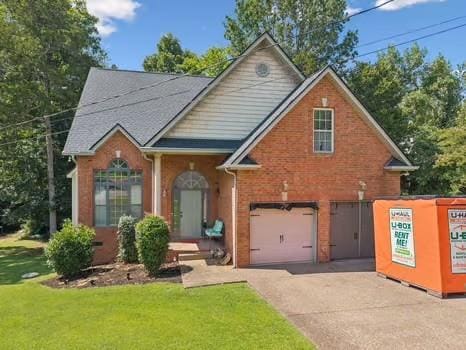 1604 Yarmouth Ct, Old Hickory, TN 37138 - view of front facade with driveway, a garage, brick siding, and a front lawn