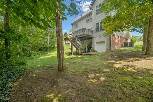 1604 Yarmouth Ct, Old Hickory, TN 37138 - view of grassy yard with a garage, a deck, and stairs