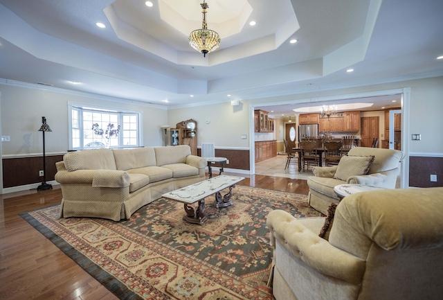 627 Eastbrook Rd, Estill Springs, TN 37330 - living room with a tray ceiling, a chandelier, a wainscoted wall, recessed lighting, and wood finished floors