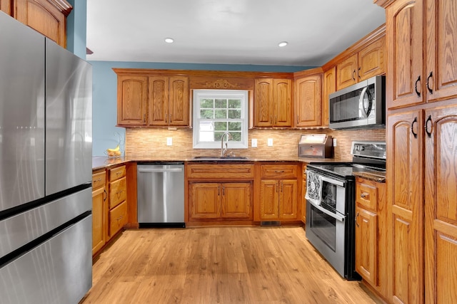 6685 Lynchburg Rd, Winchester, TN 37398 - kitchen with stainless steel appliances, brown cabinetry, light wood-style flooring, tasteful backsplash, and recessed lighting