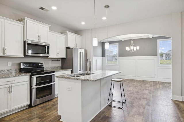 2237 Pathfinder Dr, Murfreesboro, TN 37127 - kitchen featuring stainless steel appliances, white cabinetry, dark wood-type flooring, light stone counters, and a wainscoted wall