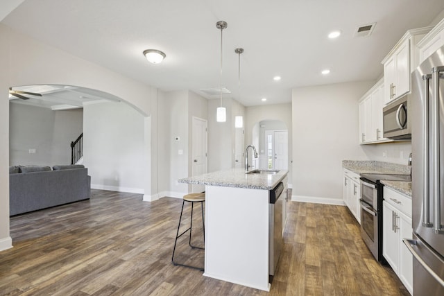 2237 Pathfinder Dr, Murfreesboro, TN 37127 - kitchen featuring stainless steel appliances, a kitchen breakfast bar, arched walkways, a center island with sink, and recessed lighting
