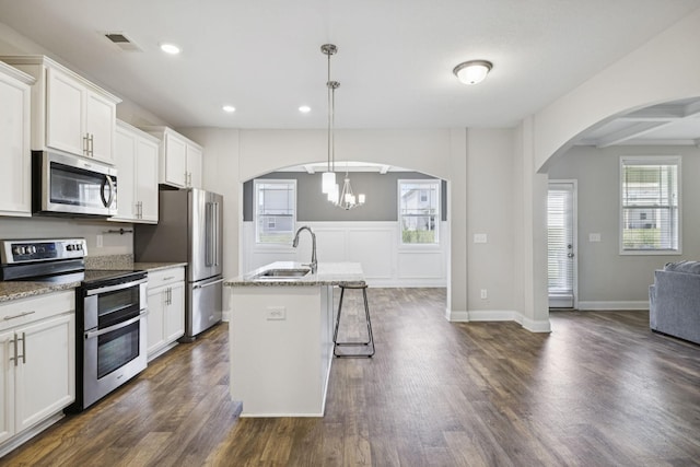 2237 Pathfinder Dr, Murfreesboro, TN 37127 - kitchen with stainless steel appliances, arched walkways, open floor plan, dark wood-style flooring, and a center island with sink