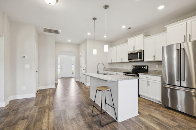 2237 Pathfinder Dr, Murfreesboro, TN 37127 - kitchen featuring arched walkways, appliances with stainless steel finishes, dark wood-style floors, an island with sink, and white cabinetry